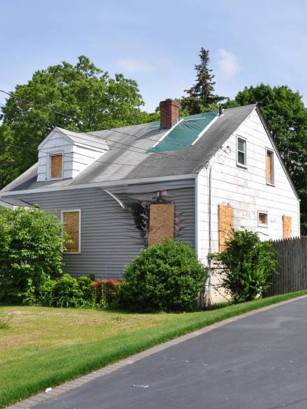 Suburban Home Fire Damage Boarded Windows Suburban Cape Cod style Home Fire Damage Boarded Windows USA